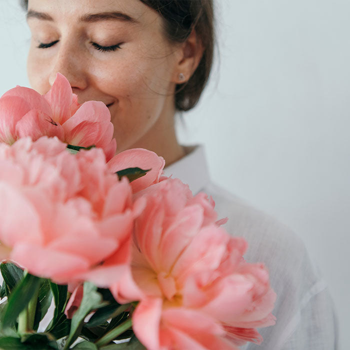 Eine Frau riecht an Blumen